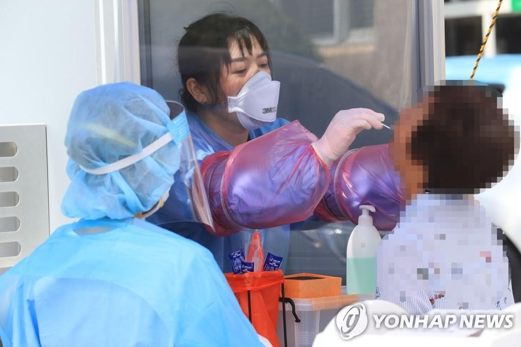 Un agent de santé effectue un prélèvement sur un citoyen dans une clinique de dépistage du Covid-19 à Seogwipo, sur l'île de Jeju, en Corée du Sud, le 28 août 2020.