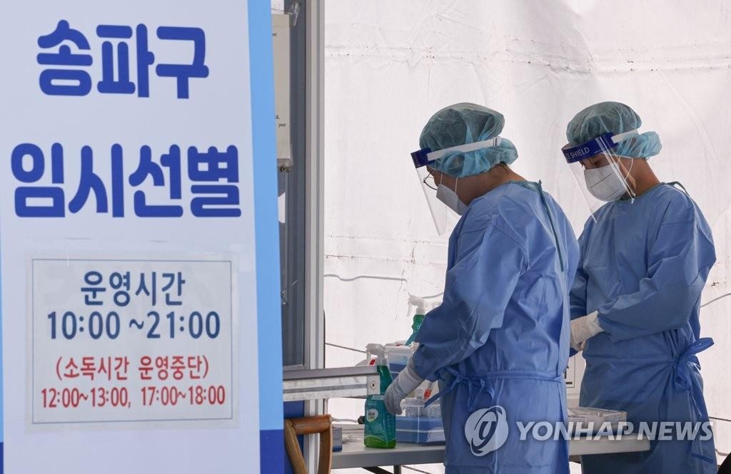 Des membres du personnel médical en combinaison de protection s'apprêtent à travailler dans un centre de dépistage à Séoul le jeudi 16 septembre 2021. 