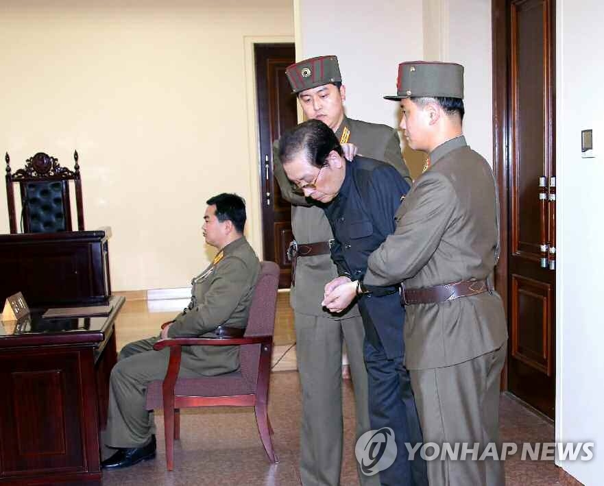 Jang Song-thaek, l'oncle du dirigeant nord-coréen Kim Jong-un, est maintenu par deux hommes avec les mains liées lors d'un procès militaire spécial mené par l'Agence de sécurité nationale. Il a été condamné à la peine de mort pour des actes anti-parti et anti-révolutionnaires et a été exécuté immédiatement, a rapporté le 13 décembre 2013 l'Agence centrale de presse nord-coréenne (KCNA). (Utilisation en Corée du Sud uniquement et redistribution interdite)