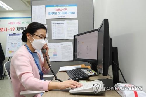 Une membre du personnel de santé s'entretient par téléphone avec un patient atteint du Covid-19 qui reçoit des soins à domicile à Séoul, le 2 décembre 2021. 
