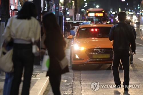 Des gens attendent un taxi à Séoul. (Photo d'archives Yonhap) 