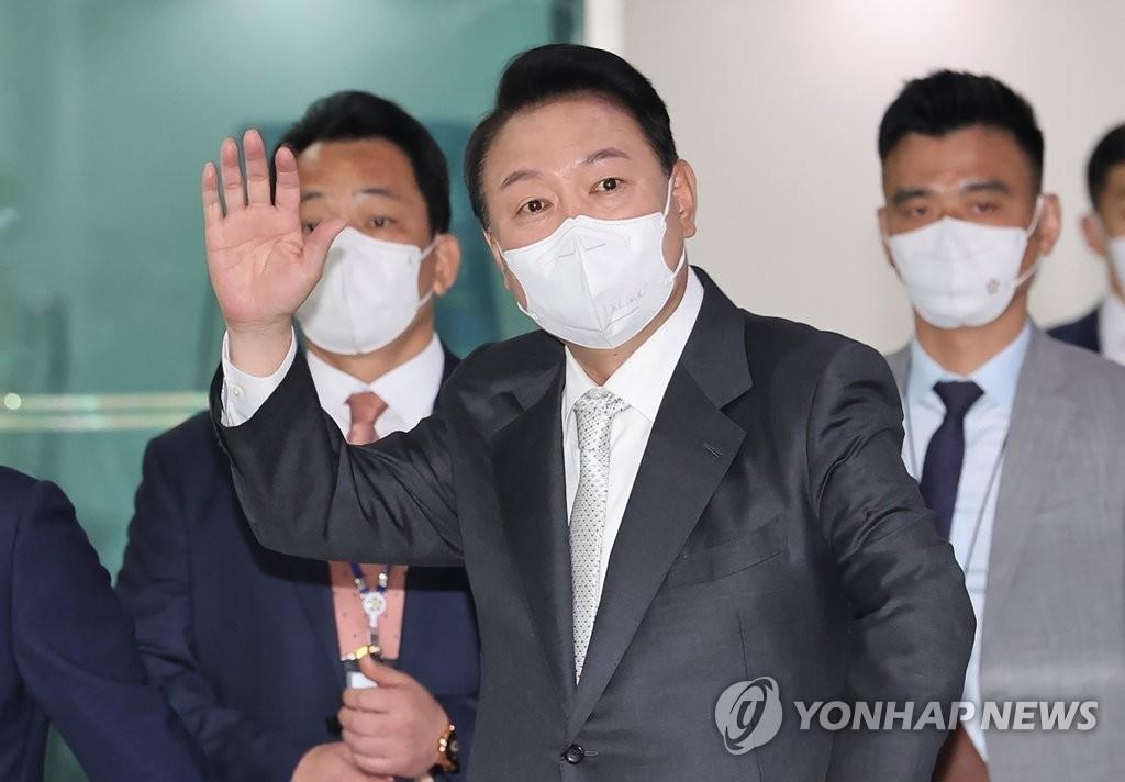 Le président Yoon Suk-yeol fait un signe de la main à son arrivée au bureau présidentiel de Yongsan, à Séoul, le 12 mai 2022.