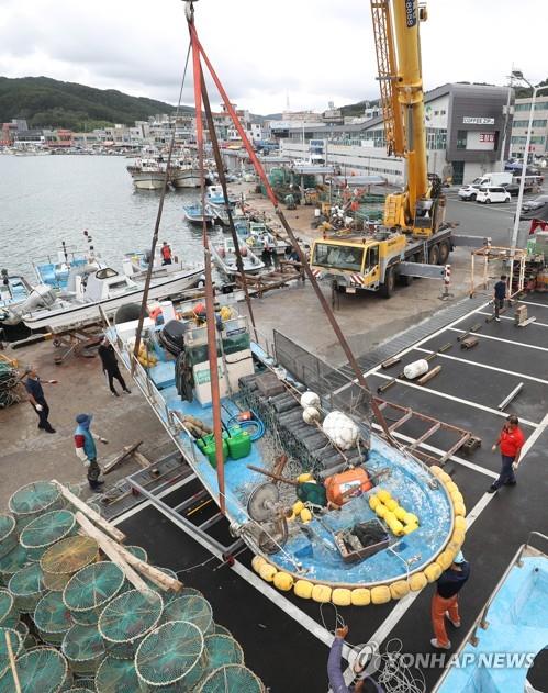 Un bâteau de pêche est déplacé vers la terre ferme dans un port d'Ulsan, dans le sud-est du pays, le 2 septembre 2022, à l'approche du typhon Hinnamnor.