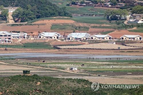Cette photo prise le vendredi 15 avril 2022 depuis l'observatoire sud-coréen d'Odu à Paju, dans la province du Gyeonggi, montre des habitants du comté frontalier nord-coréen de Kaepung, dans la province du Hwanghae du Nord, travaillant sur un terrain agricole.