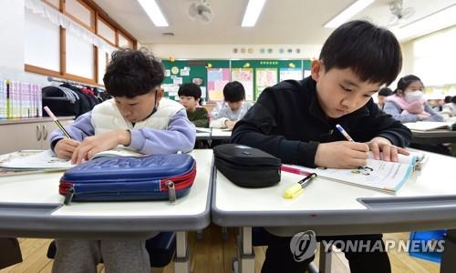 Des écoliers sans masque suivent un cours dans une salle de classe à l'école élémentaire Samduck à Daegu, dans le sud-est du pays, le lundi 30 janvier 2023, le jour de la levée de l'obligation de port du masque à l'intérieur. 