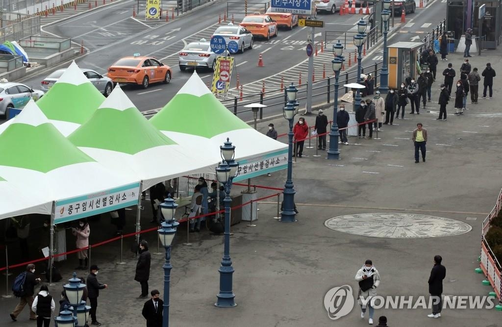 旧正月連休初日の１１日もソウル駅前の広場に設置された新型コロナウイルスの臨時検査所には検査を待つ人の列ができている＝１１日、ソウル（聯合ニュース）