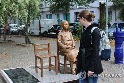 ベルリン市内に設置された少女像を見つめる現地の市民（資料写真）＝（聯合ニュース）