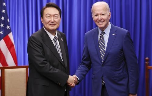 握手を交わす尹大統領とバイデン大統領＝１３日、プノンペン（聯合ニュース）