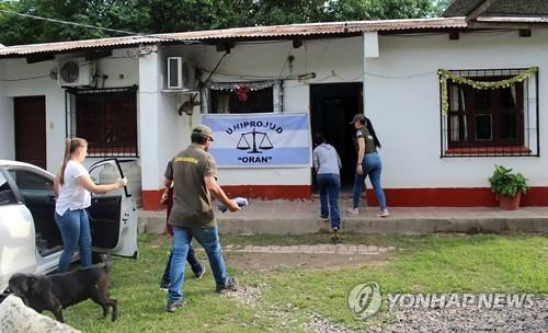 32년만에 구출된 아르헨티나여성(오른쪽에서 두번째)과 아들(모자 남성에 가려있음)