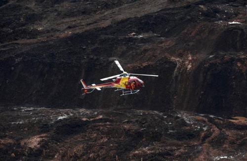 브라질 남동부 광산 댐 붕괴사고 현장에서 헬기가 실종자 수색작업을 벌이고 있다. [브라질 일간 에스타두 지 상파울루]