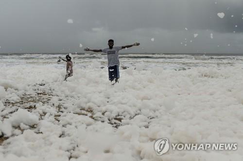 1일 오염된 흰 거품 속에서 뛰노는 인도 남부 첸나이 마리나 해변의 어린이들. [AFP=연합뉴스]
