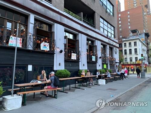 사람들이 미국 뉴욕의 한 식당 바깥에서 칵테일을 마시고 있다. [AFP=연합뉴스 자료사진]
