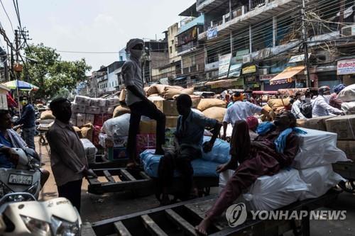 12일 인도 뉴델리 파테푸리 시장에서 쉬고 있는 노동자들. [AFP=연합뉴스]