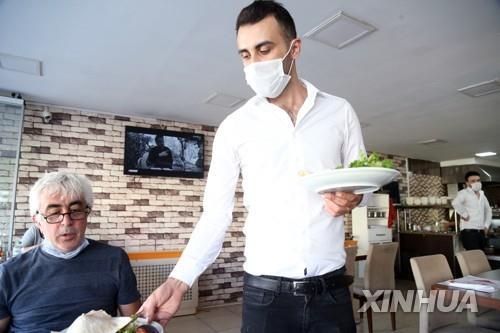 마스크를 착용하고 손님 접대하는 터키 수도 앙카라의 식당 종업원 [신화=연합뉴스 자료사진]