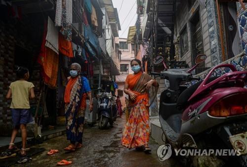 인도 뭄바이의 슬럼가 다라비에서 마스크를 쓰고 지나가는 주민. [AFP=연합뉴스 자료사진]