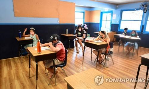 마스크를 한 채 간격을 두고 앉은 미국 캘리포니아주의 초등학생들