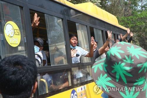 24일 교도소에서 석방된 이들이 버스를 타고 나오며 세 손가락 경례를 고 있다. [AP=연합뉴스]