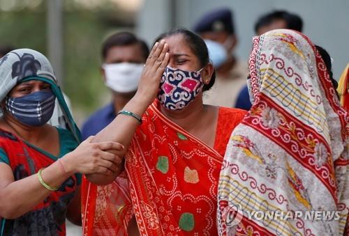 코로나19로 남편을 잃은 아내(가운데)가 인도 아메다바드 병원 영안실에서 슬퍼하는 모습. [로이터=연합뉴스]