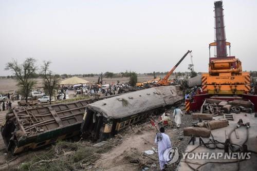 7일 파키스탄 남부에서 발생한 열차 충돌 사고 현장에서 진행된 구조 작업 모습. [AFP=연합뉴스]