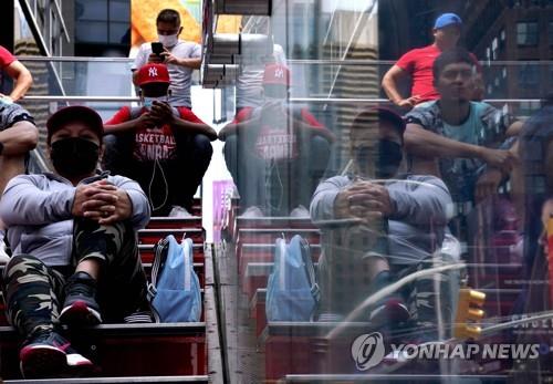 22일(현지시간) 미국 뉴욕의 타임스스퀘어에 마스크를 쓴 사람들이 앉아 있다. [AFP=연합뉴스]
