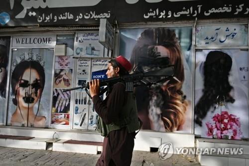 '여성 사진 훼손' 미용실 앞 지나는 탈레반 병사