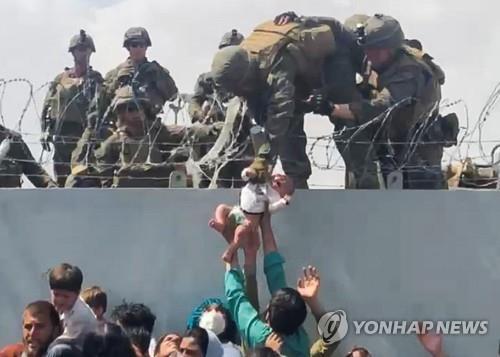 아기 건네받는 미군