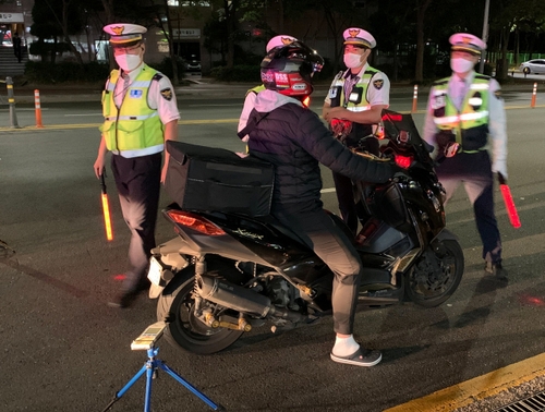 경찰이 오토바이 소음을 측정하는 모습