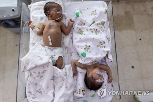아프간의 한 병원에서 아기 두 명이 한 침대에 누워있는 모습.
