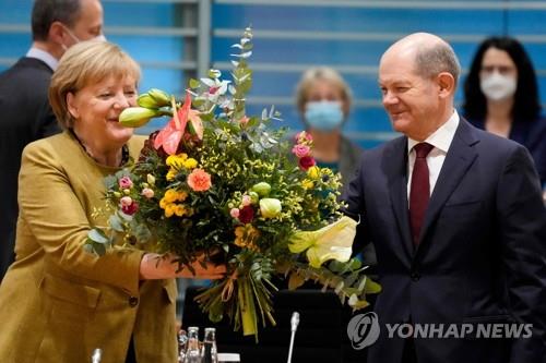 숄츠 차기 총리 후보로부터 꽃다발 받는 메르켈 독일 총리 대행