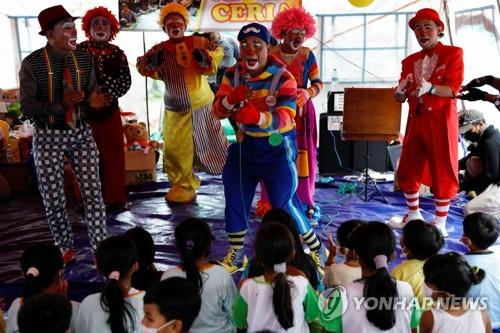 스메루 화산 폭발 피해 어린이들에게 공연하는 광대들
