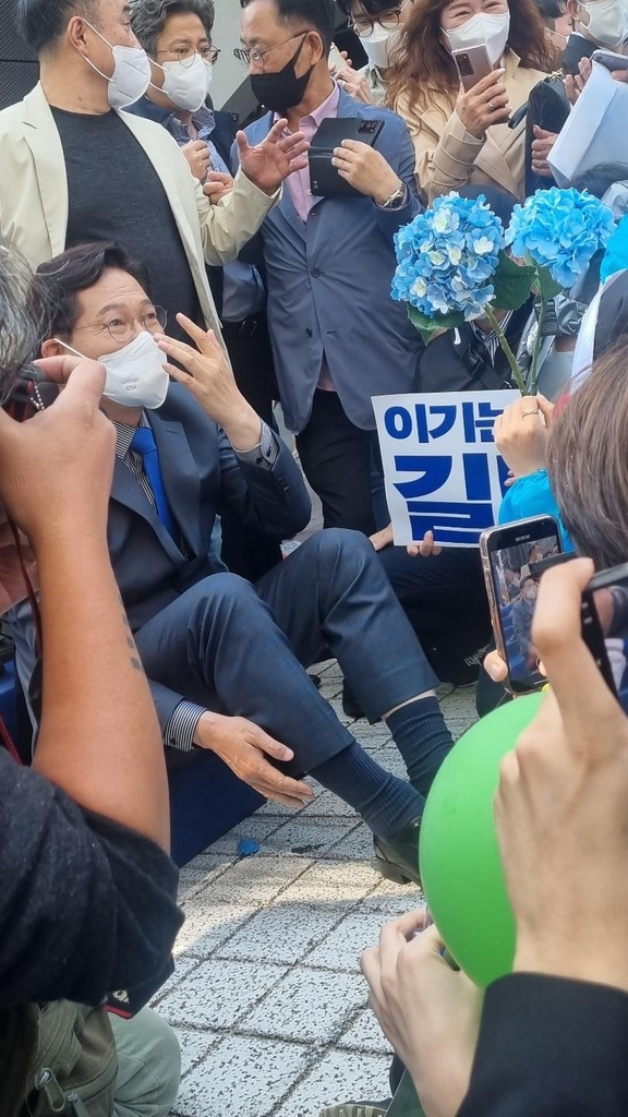 바닥에 앉아 지지자들과 사진 촬영하는 송영길 전 대표