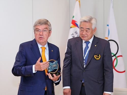 토마스 바흐(왼쪽) IOC 위원장이 조정원 WT 총재에게 'IOC 위원장 트로피'를 수여하는 모습.<BR><BR>[세계태권도연맹 제공. 재판매 및 DB 금지]