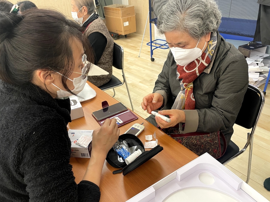 서울 중구 건강관리 사업에 참여하는 어르신이 건강기기 사용법을 배우는 모습.