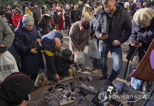 우크라이나 남부 헤르손 주민들이 자택 전기가 끊긴 탓에 중앙 광장에 모여 휴대전화를 충전하는 모습 [AP 연합뉴스 자료사진. 재판매 및 DB 금지] 
