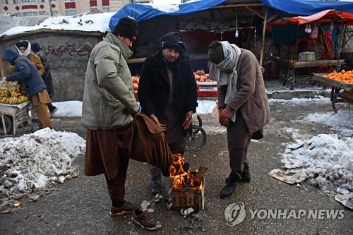 아프간 마자르-이-샤리프에서 모닥불을 피워 몸을 녹이는 남성.