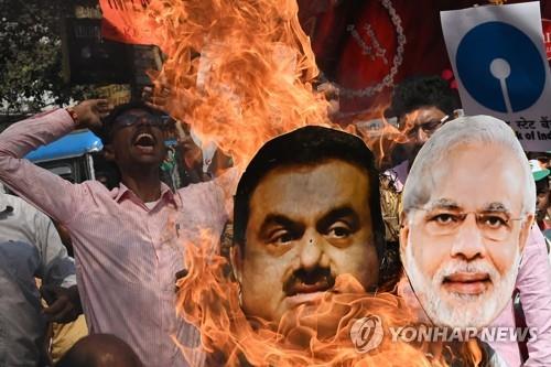 6일 인도 콜카타에서 모디 총리와 아다니 회장의 인형을 불태우는 시위대.