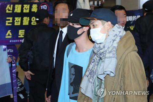 Los miembros de BTS RM (dcha.) y Jin llegan, el 24 de octubre de 2018, al Aeropuerto Internacional de Incheon, al oeste de Seúl.