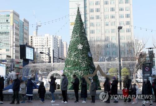 Los ciudadanos esperan en fila para ser examinados del coronavirus, el 6 de diciembre de 2021, en una clínica provisional en Incheon, al oeste de Seúl.