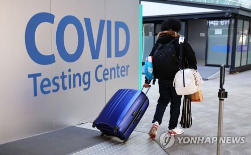 Una persona camina hacia un centro de pruebas del coronavirus instalado en el Aeropuerto Internacional de Incheon, al oeste de Seúl, al llegar a Corea del Sur, el 13 de enero de 2022.