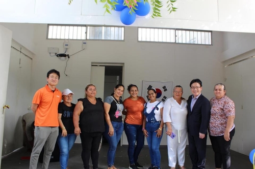 La foto sin fechar, proporcionada por la KOICA, muestra a empleados de la agencia tomándose fotos con residentes en un centro comunitario, en Colombia, construido por la agencia como parte de los programas para apoyar el asentamiento de los desplazados colombianos. (Prohibida su reventa y archivo)