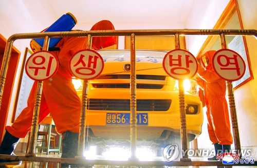 La foto, publicada, el 23 de mayo de 2022, por la KCNA, muestra a trabajadores desinfectando un vehículo en una oficina de correos, en Pyongyang, en medio de la pandemia del coronavirus. (Uso exclusivo dentro de Corea del Sur. Prohibida su distribución parcial o total)