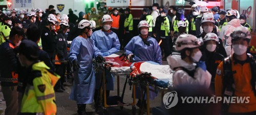 La foto, tomada el 30 de octubre de 2022, muestra a trabajadores sanitarios en el barrio de Itaewon, en el centro de Seúl, donde sucedió una estampida humana, durante las fiestas de Halloween, que dejó muertos y heridos.