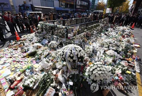 Un montón de flores y ofrendas de condolencia, colocadas por los ciudadanos de luto, yacen, el 2 de noviembre de 2022, alrededor de una salida de la estación de metro de Itaewon, en Seúl.
