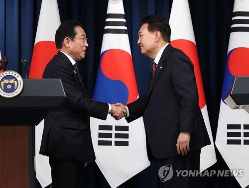 La foto de archivo muestra al presidente de Corea del Sur, Yoon Suk Yeol (dcha.), estrechando la mano del primer ministro de Japón, Fumio Kishida, el 7 de mayo de 2023, tras una conferencia de prensa conjunta, en la oficina presidencial surcoreana, en Seúl.
