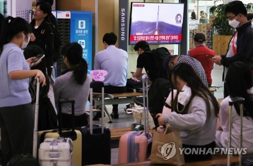 Las personas miran sus teléfonos móviles, el 31 de mayo de 2023, en la estación de Seúl, en la capital surcoreana.