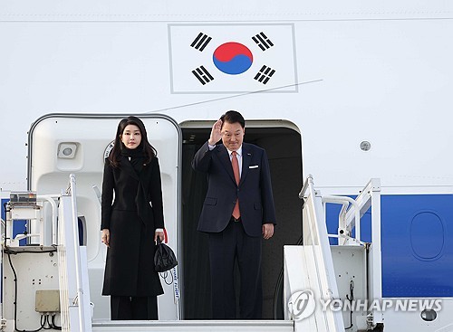 En la foto de archivo se muestra al presidente surcoreano, Yoon Suk Yeol (dcha.), saludando junto a la primera dama, Kim Keon Hee, en un aeropuerto de Ámsterdam, los Países Bajos, el 14 de diciembre de 2023, antes de regresar a casa después de una visita de Estado, de cuatro días, al país europeo. 