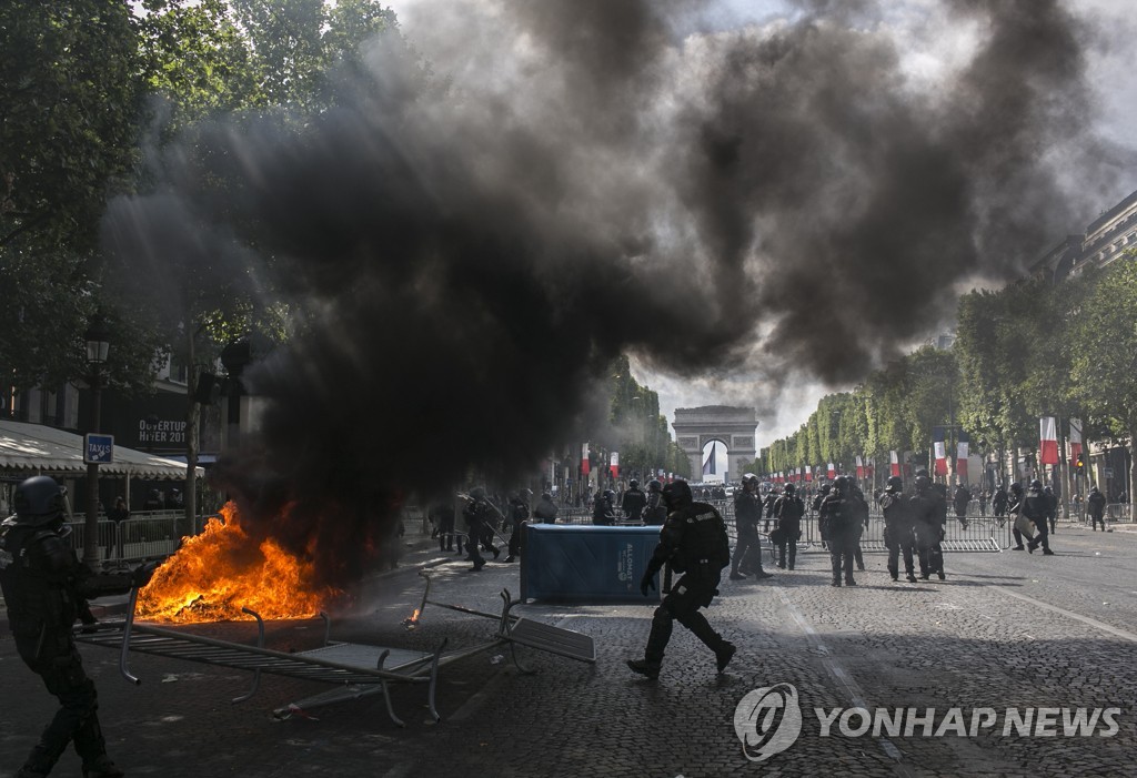 14일 프랑스 파리 샹젤리제 거리에서 군사 열병식이 끝난 뒤 시위대와 경찰이 대치하는 모습. [AP=연합뉴스] 