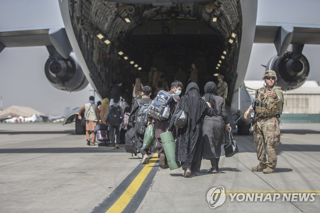 카불 공항에서 미군 대피기에 탑승하고 있는 사람들. [AP=연합뉴스 자료 사진]