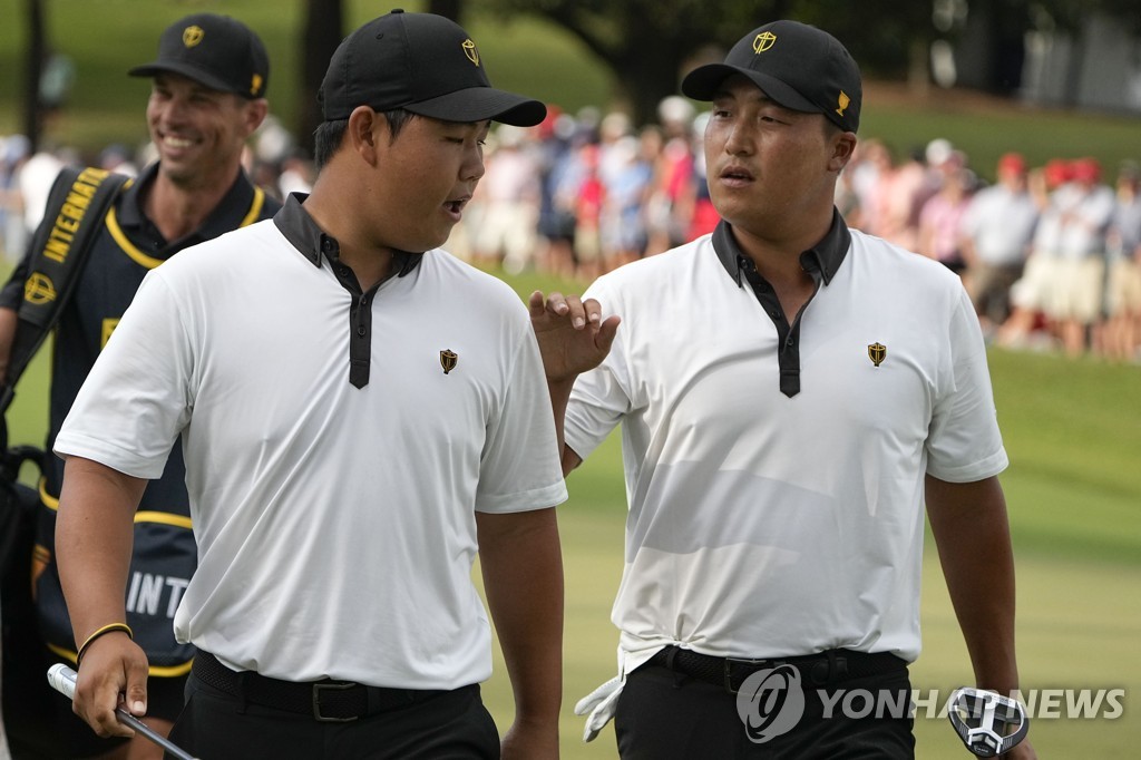 Kim Joo-hyung (L) and Lee Kyoung-hoon, two South Korean teammates for the International Team, walk off the 16th green during their foursome match against Cameron Young and Collin Morikawa of the United States at the Presidents Cup at Quail Hollow Club in Charlotte, North Carolina, on Sept. 22, 2022. (Yonhap)
