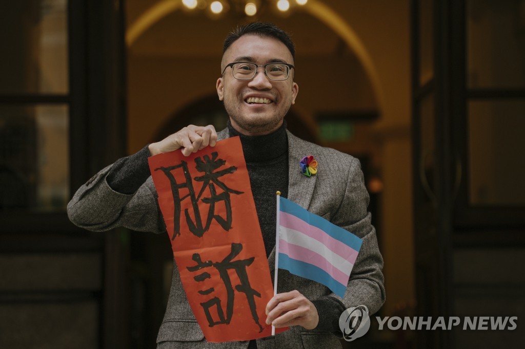 (AP=연합뉴스) 홍콩 트랜스젠더 활동가 헨리 에드워드 쯔가 지난 6일 홍콩 법원의 판결을 환영하며 '승소'라고 적힌 종이를 들어 보인 모습. 2023.2.7.